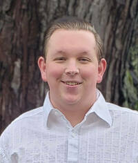 Portrait of John McDonaugh in white shirt.